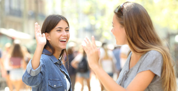 two women waving at each other