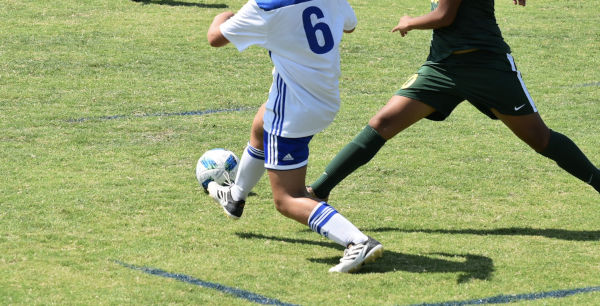 two footballers, one tackling the other