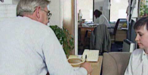 a man writing at a desk