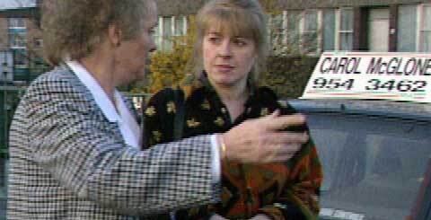 two women with a car in the background