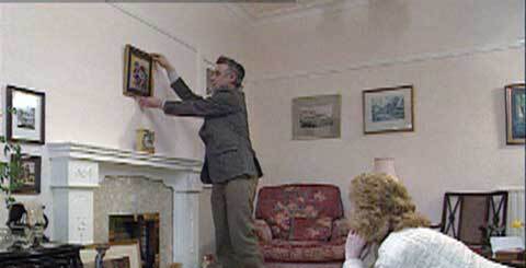 a man hanging up a picture